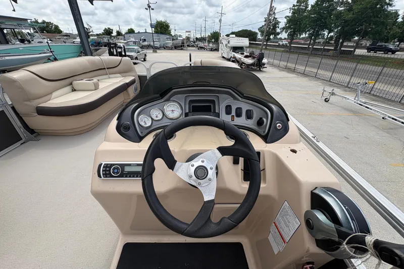 Slide: The Image of 2016 Sun Tracker Party Barge 20 DLX helm with steering wheel and dashboard controls. - 16