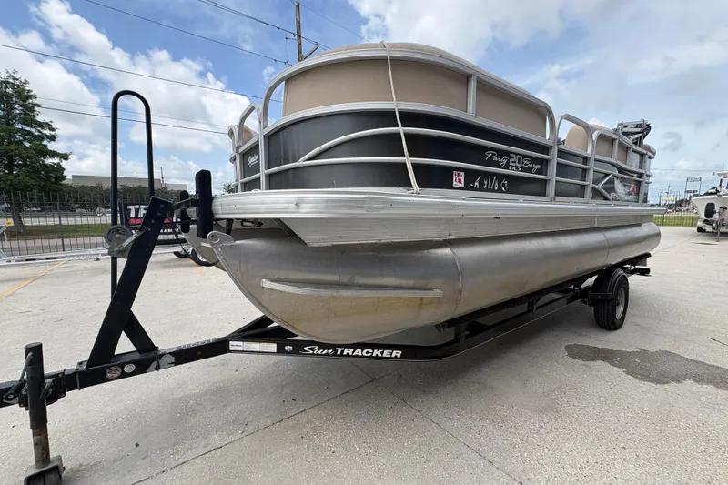 Slide: The Image of 2016 Sun Tracker Party Barge 20 DLX pontoon boat on trailer, parked outdoors. - 8