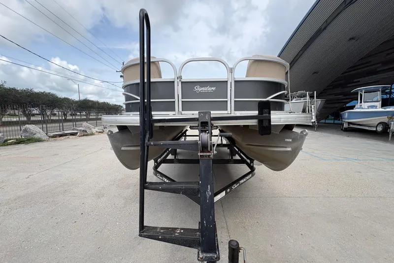 Slide: The Image of 2016 Sun Tracker Party Barge 20 DLX pontoon boat on trailer, outdoor setting. - 9
