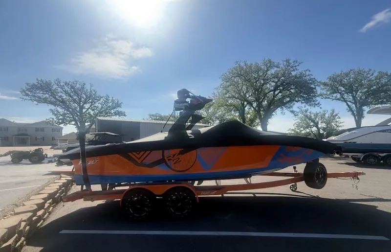 Slide: The Image of 2016 Tigé RZ2 boat on trailer under sunny skies. - 1