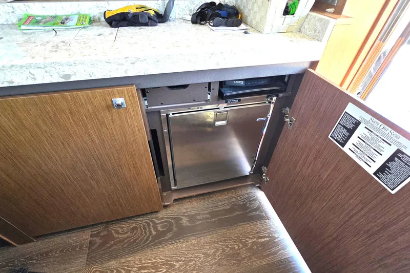 Slide: The Image of 2018 Sea Ray Sundancer 510 yacht interior with open cabinet revealing stainless steel appliance. - 10