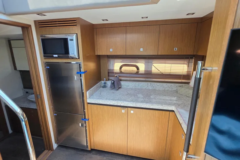 Slide: The Image of Luxurious 2018 Sea Ray Sundancer 510 yacht kitchen with modern appliances and wood cabinetry. - 11