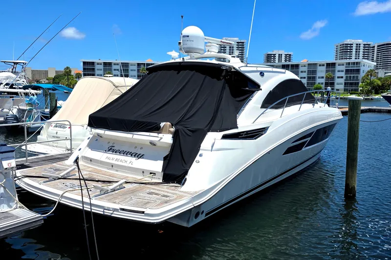 Slide: The Image of 2018 Sea Ray Sundancer 510 yacht docked in a marina under a clear blue sky. - 2