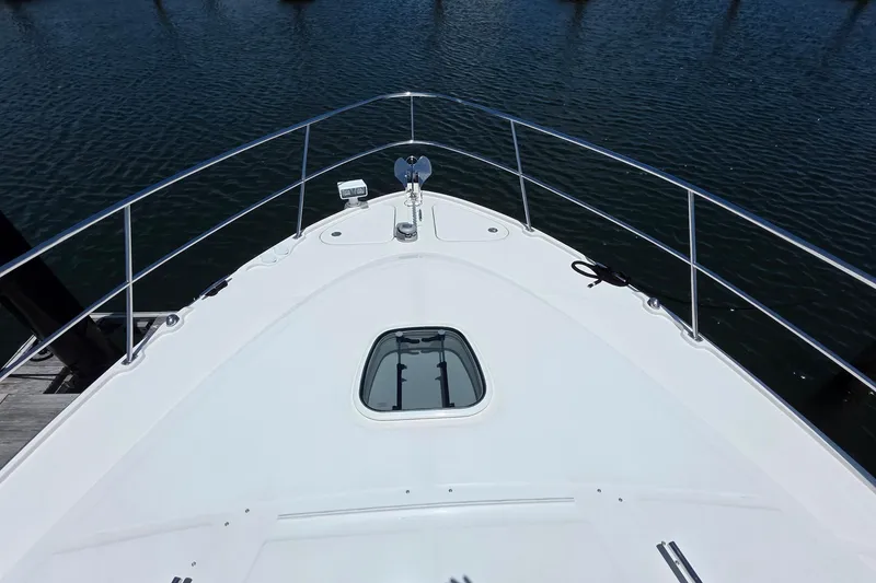 Slide: The Image of 2018 Sea Ray Sundancer 510 yacht bow view, featuring sleek design and open water backdrop. - 28