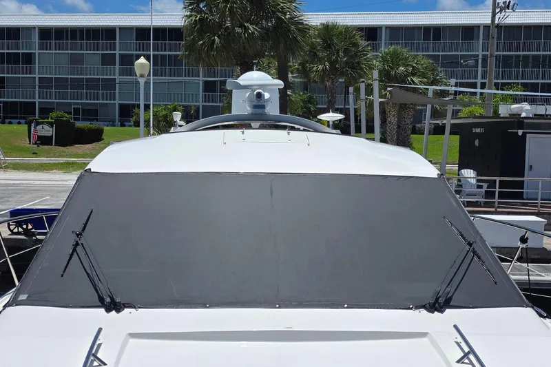 Slide: The Image of 2018 Sea Ray Sundancer 510 yacht docked, featuring sleek design and tinted windshield. - 31