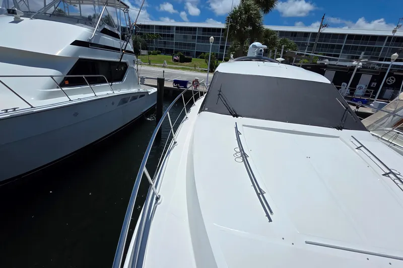 Slide: The Image of 2018 Sea Ray Sundancer 510 yacht docked beside another boat under a clear blue sky. - 37