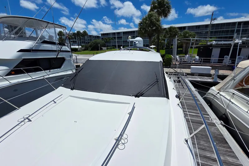 Slide: The Image of 2018 Sea Ray Sundancer 510 yacht docked at marina under clear blue sky. - 38