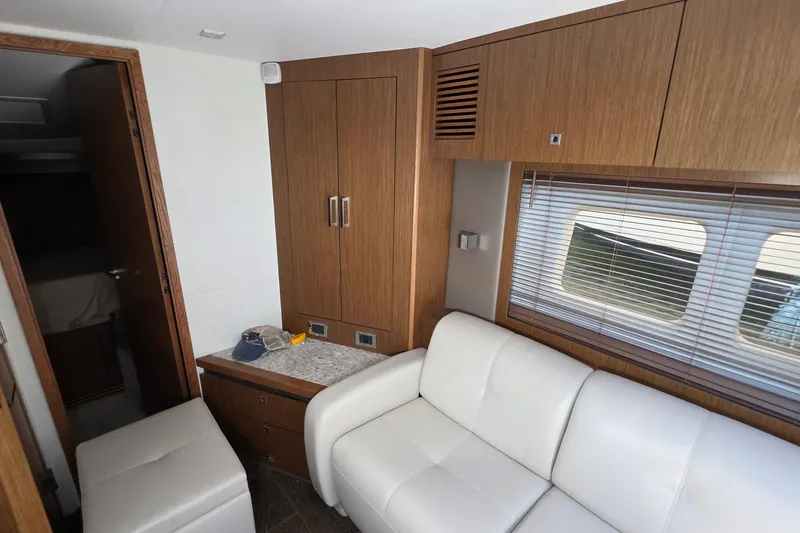 Slide: The Image of Interior of 2018 Sea Ray Sundancer 510 yacht with white leather seating and wooden cabinetry. - 42