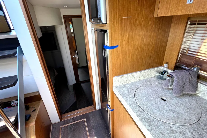 Slide: The Image of Interior of 2018 Sea Ray Sundancer 510 yacht, featuring a compact kitchen area. - 58