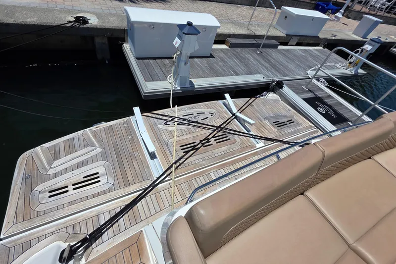 Slide: The Image of 2018 Sea Ray Sundancer 510 yacht docked, featuring teak swim platform and beige seating. - 78
