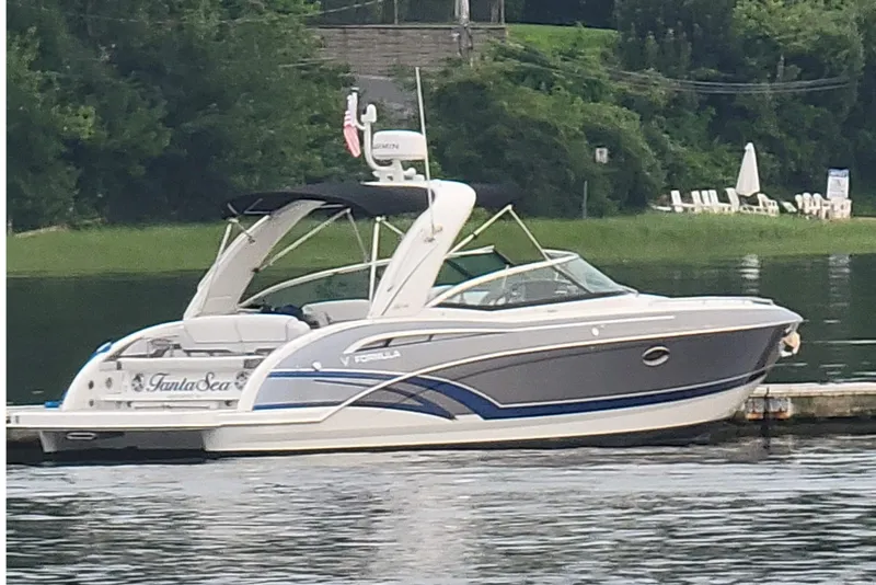 The Image of 2016 Formula 310 Bowrider boat docked on a serene lake. - 10