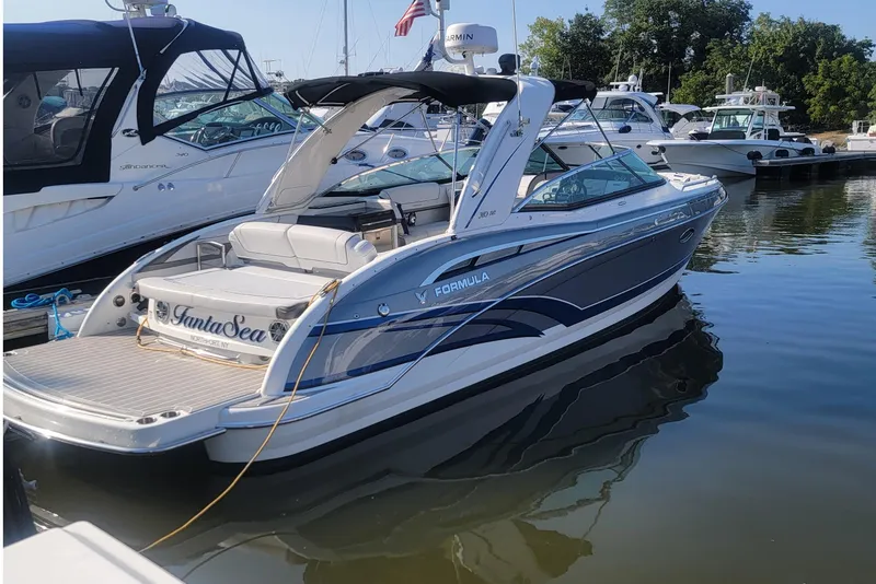 Slide: The Image of 2016 Formula 310 Bowrider boat docked in marina, sleek design, calm water reflection. - 12