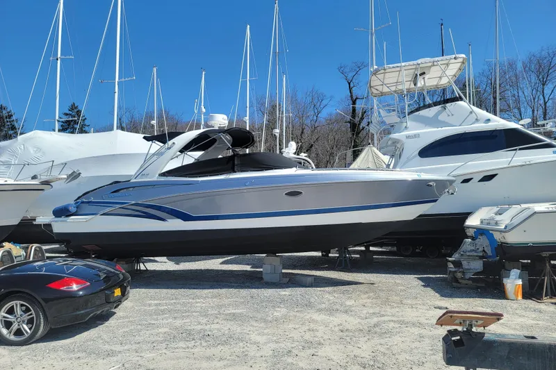 Slide: The Image of 2016 Formula 310 Bowrider boat in storage, surrounded by other vessels and a car. - 13