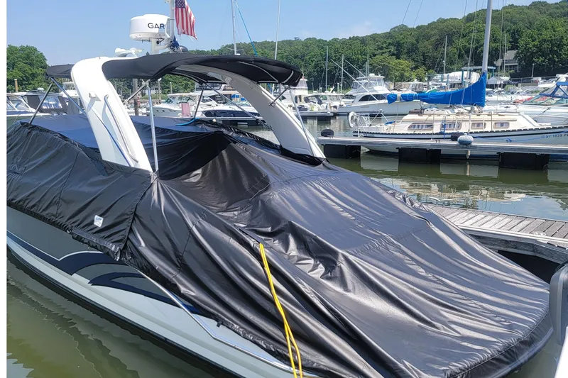Slide: The Image of 2016 Formula 310 Bowrider covered at marina, surrounded by boats and lush greenery. - 20