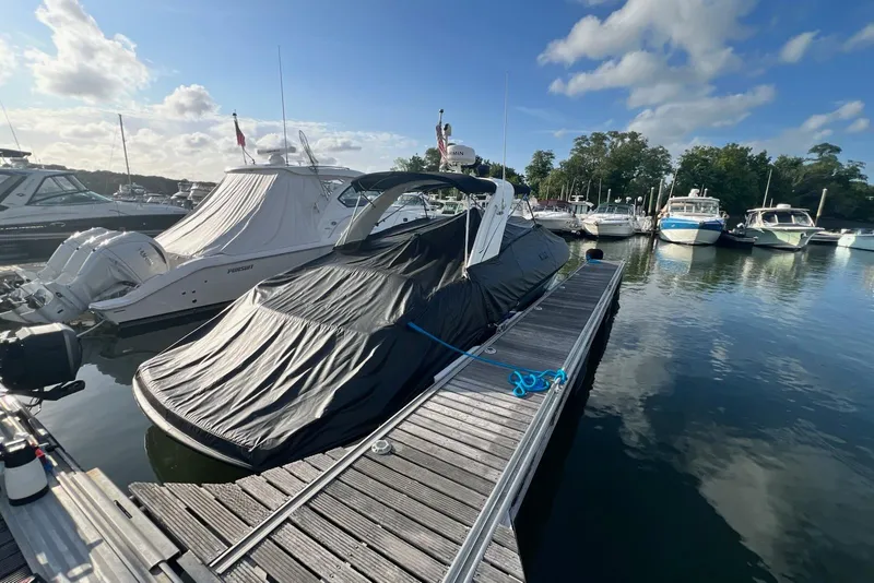 Slide: The Image of 2016 Formula 310 Bowrider covered at marina dock, surrounded by other boats. - 21
