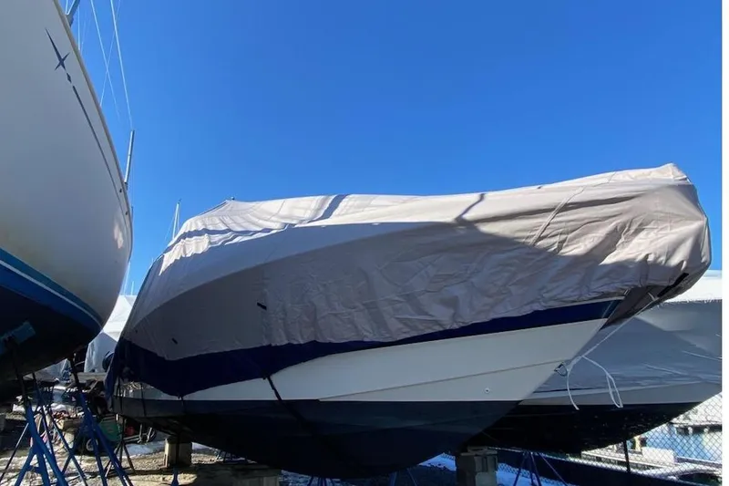 Slide: The Image of 2016 Formula 310 Bowrider boat covered and stored outdoors under a clear blue sky. - 23