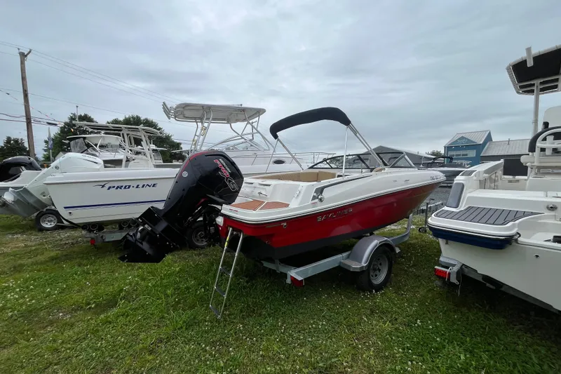 Slide: The Image of 2024 Bayliner VR4 Bowrider OB in red, parked on a trailer, with outboard motor. - 1