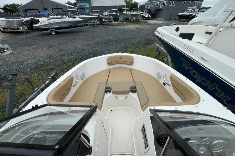 Slide: The Image of 2024 Bayliner VR4 Bowrider OB with tan seating, docked among other boats. - 3