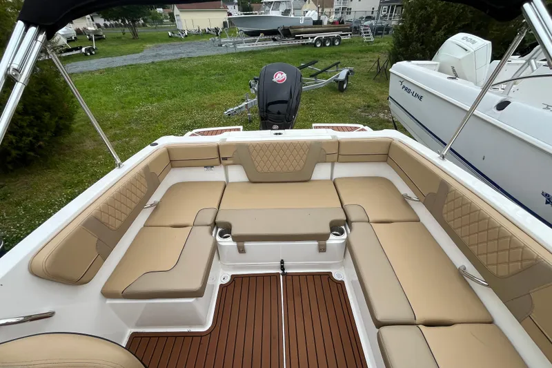 Slide: The Image of 2024 Bayliner VR4 Bowrider OB interior with tan seating and wood-style flooring. - 5