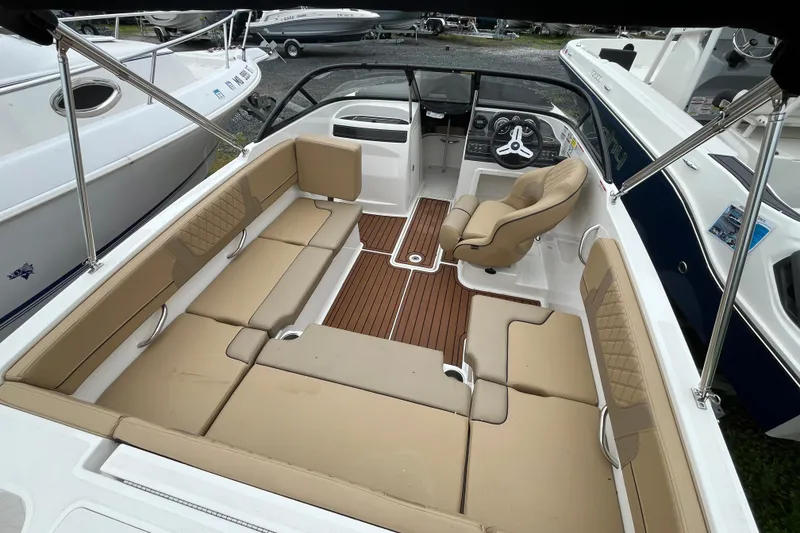 Slide: The Image of 2024 Bayliner VR4 Bowrider OB interior with tan seating and wood-style flooring. - 7