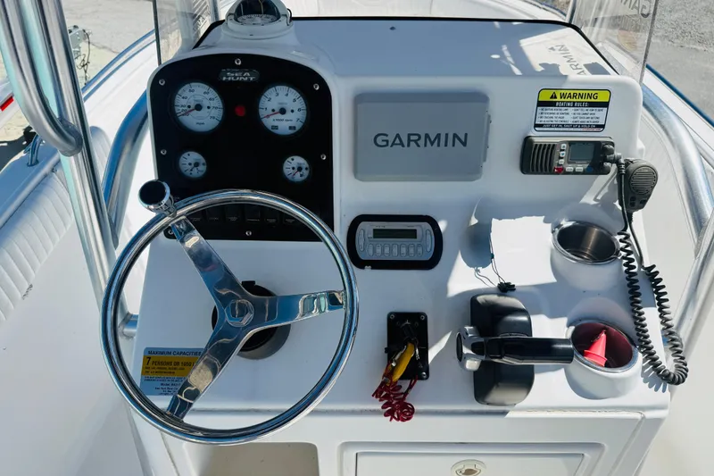 Slide: The Image of 2008 Sea Hunt Ultra 210 boat dashboard with Garmin GPS, steering wheel, and control panel. - 2