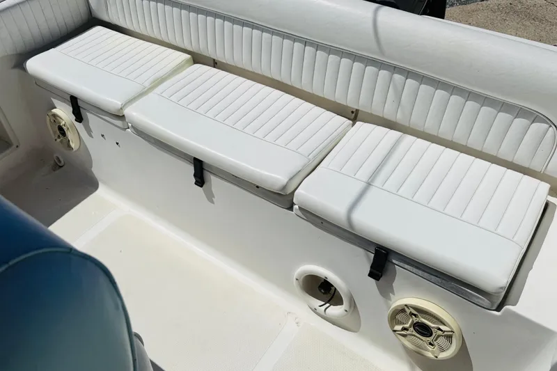 Slide: The Image of White cushioned seating on a 2008 Sea Hunt Ultra 210 boat, featuring built-in speakers. - 5