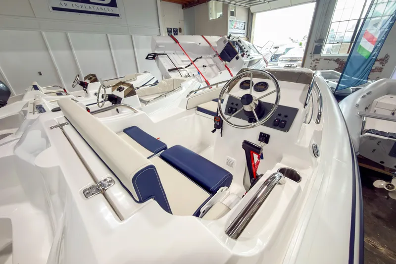 Slide: The Image of 2023 AB Inflatables Nautilus 13 boat interior with steering wheel and seating in showroom. - 19