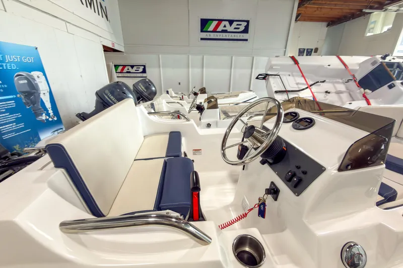 Slide: The Image of 2023 AB Inflatables Nautilus 13 boat interior with steering wheel and seating in showroom. - 20