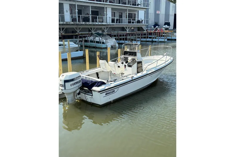 The Image of 1993 Boston Whaler 21 Outrage boat docked with Evinrude motor in marina. - 0