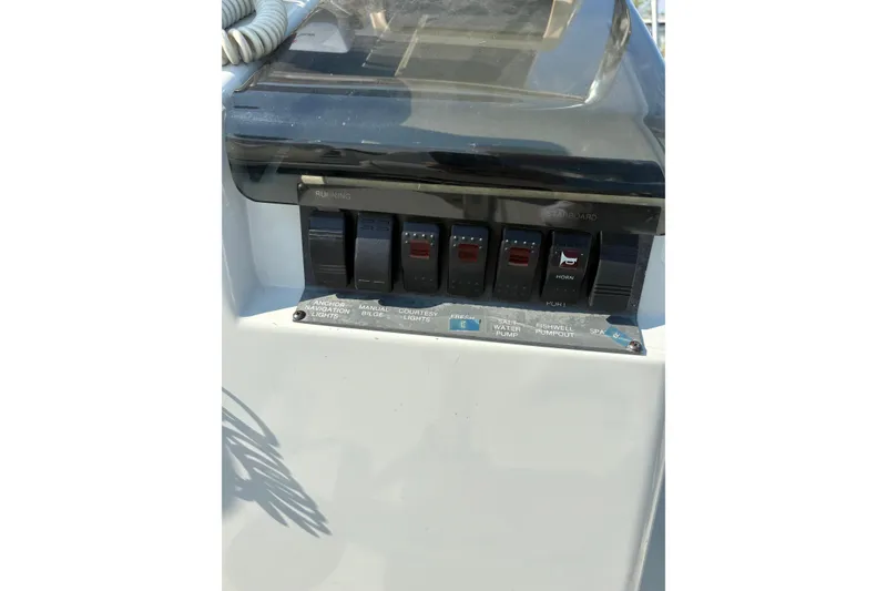 Slide: The Image of Control panel of a 1993 Boston Whaler 21 Outrage boat with labeled switches. - 13
