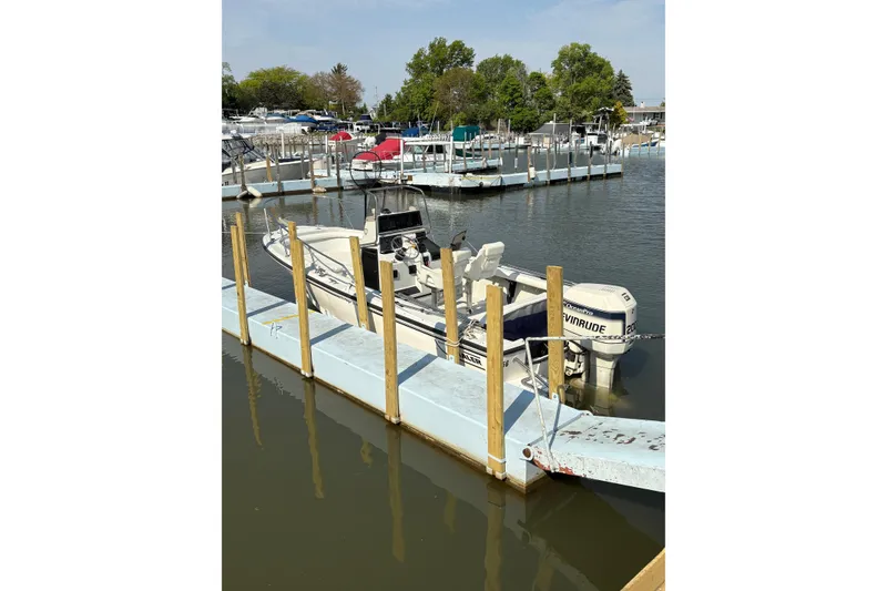 Slide: The Image of 1993 Boston Whaler 21 Outrage docked at a marina with Evinrude outboard motor. - 2