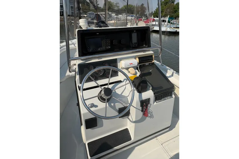 Slide: The Image of 1993 Boston Whaler 21 Outrage boat helm with steering wheel and navigation equipment. - 4