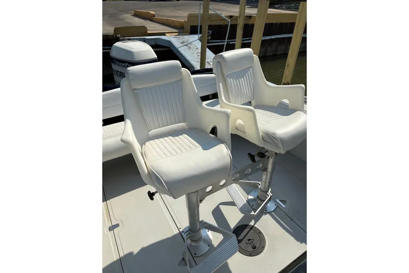 Slide: The Image of Two white swivel seats on a 1993 Boston Whaler 21 Outrage boat deck. - 7