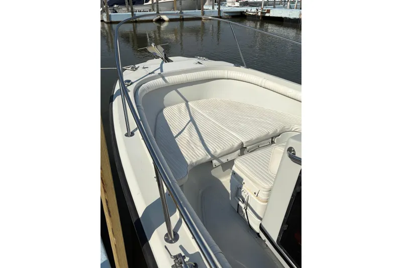 Slide: The Image of 1993 Boston Whaler 21 Outrage boat with white seating, docked in a marina. - 9