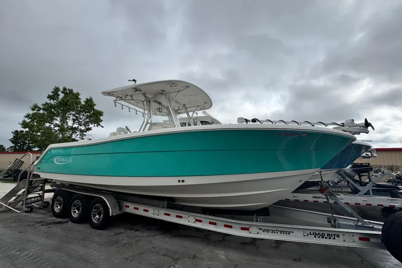 The Image of 2007 Robalo R300 Center Console boat on trailer under cloudy sky. - 0