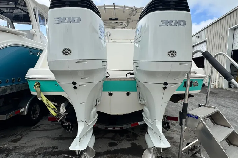 Slide: The Image of 2007 Robalo R300 Center Console with twin 300 horsepower outboard engines at a marina. - 2