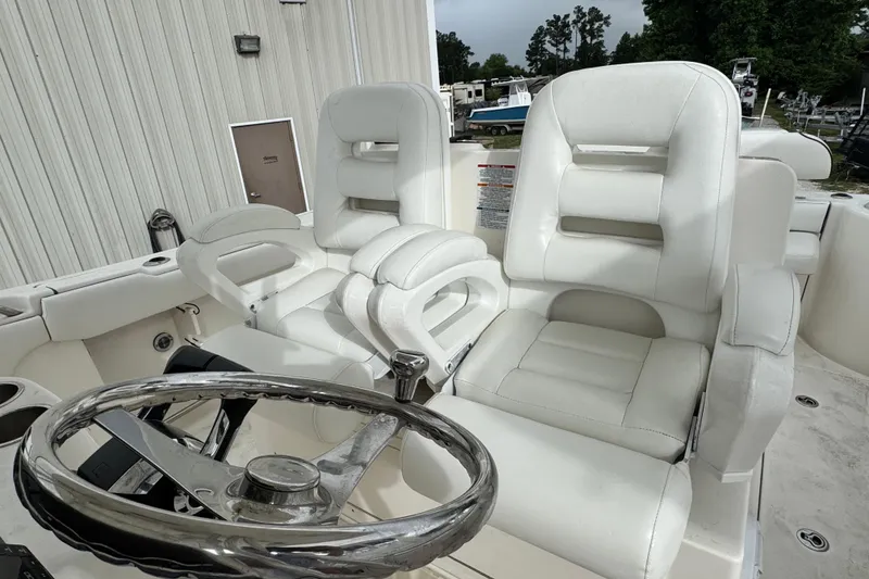 Slide: The Image of 2007 Robalo R300 Center Console boat with white leather seating and steering wheel. - 6