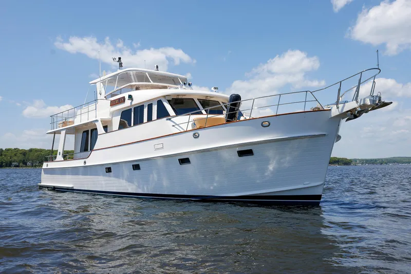 Slide: The Image of 2007 Grand Banks 59 Aleutian RP yacht on calm water under blue sky. - 101