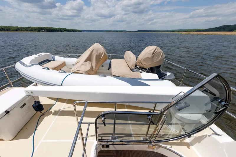 Slide: The Image of 2007 Grand Banks 59 Aleutian RP yacht with covered dinghy on deck, scenic water view. - 15