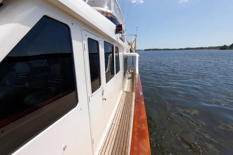 Slide: The Image of Side view of 2007 Grand Banks 59 Aleutian RP yacht on calm water. - 24