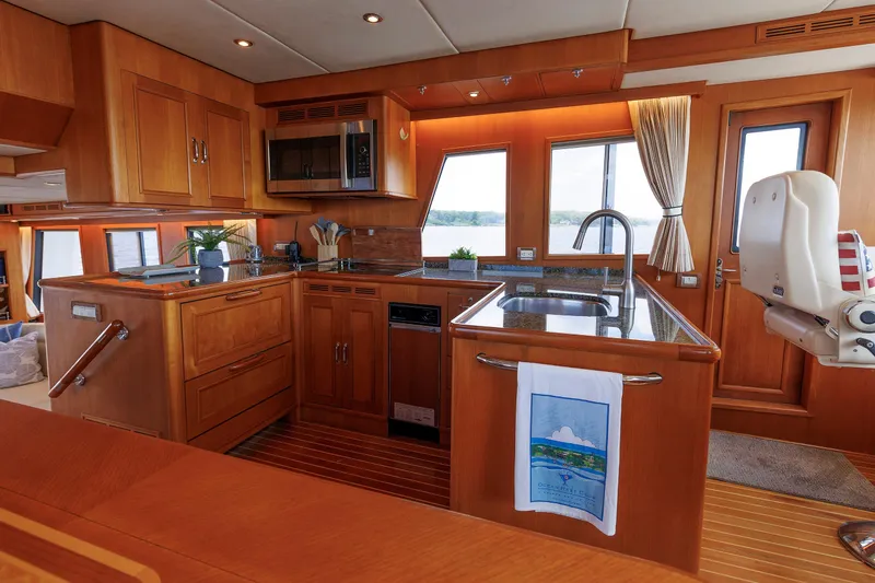 Slide: The Image of Luxurious 2007 Grand Banks 59 Aleutian RP yacht kitchen with wood cabinetry and modern appliances. - 41