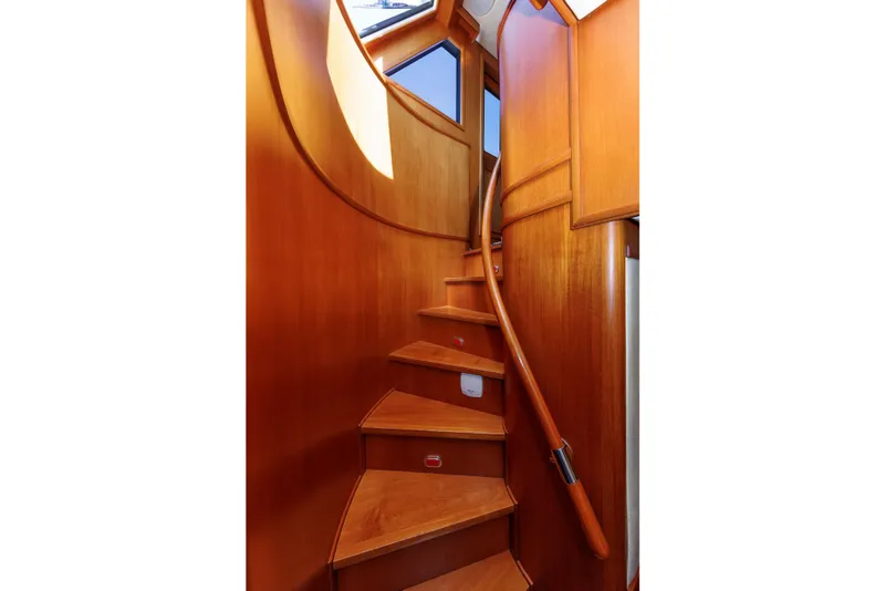 Slide: The Image of Wooden staircase inside 2007 Grand Banks 59 Aleutian RP yacht, featuring elegant curved design. - 51