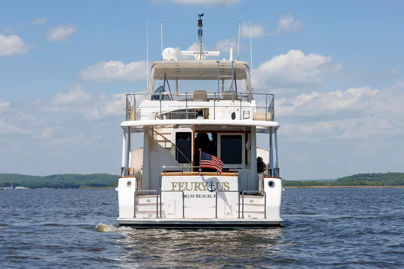 Slide: The Image of 2007 Grand Banks 59 Aleutian RP yacht on open water, rear view with American flag. - 8