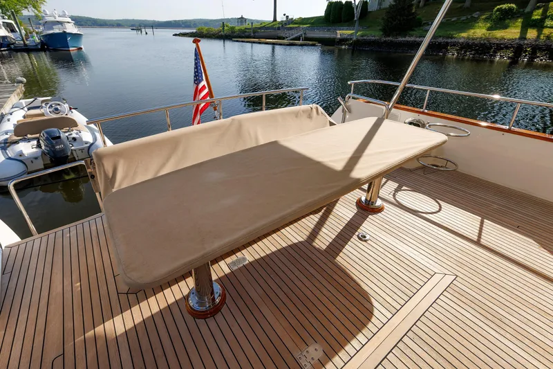 Slide: The Image of 2007 Grand Banks 59 Aleutian RP yacht deck with table, overlooking serene waterfront. - 82