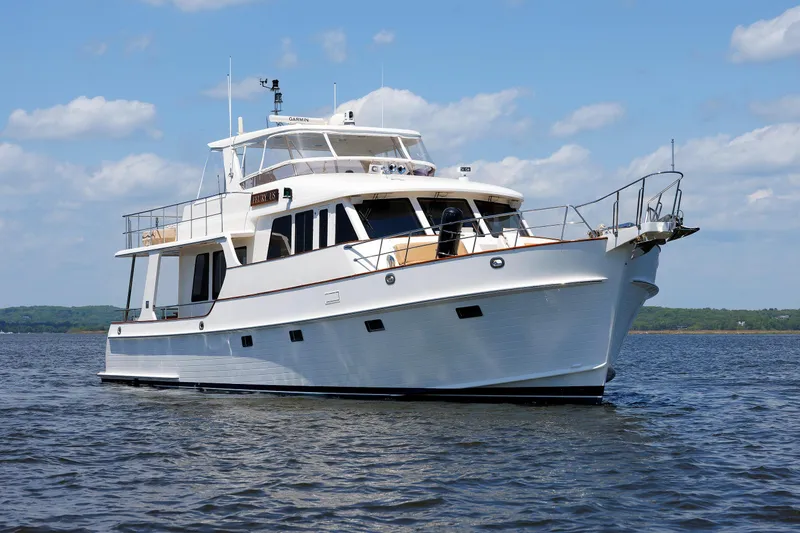 Slide: The Image of 2007 Grand Banks 59 Aleutian RP yacht on calm water under a blue sky. - 95
