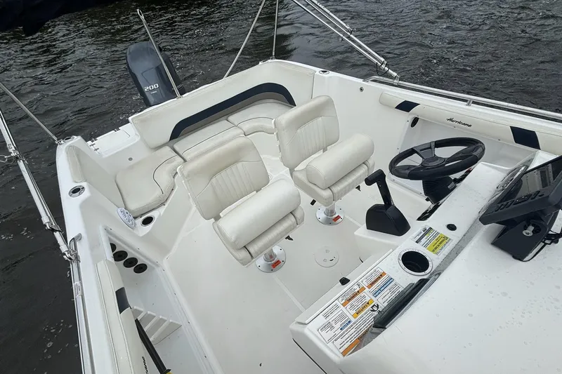 Slide: The Image of 2015 Hurricane SunDeck Sport 231 OB boat interior with steering wheel and seating. - 10