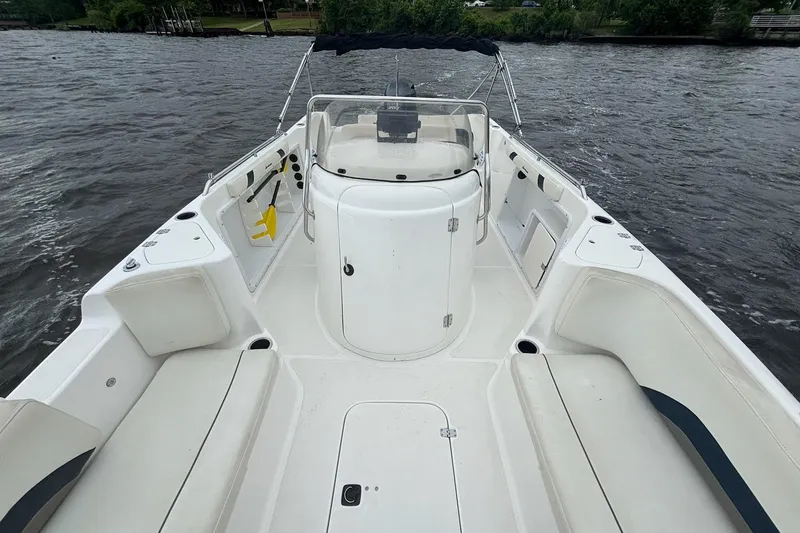 Slide: The Image of 2015 Hurricane SunDeck Sport 231 OB boat interior with seating and console on water. - 11