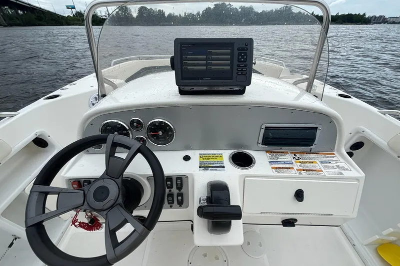 Slide: The Image of 2015 Hurricane SunDeck Sport 231 OB boat dashboard with steering wheel and navigation system. - 14