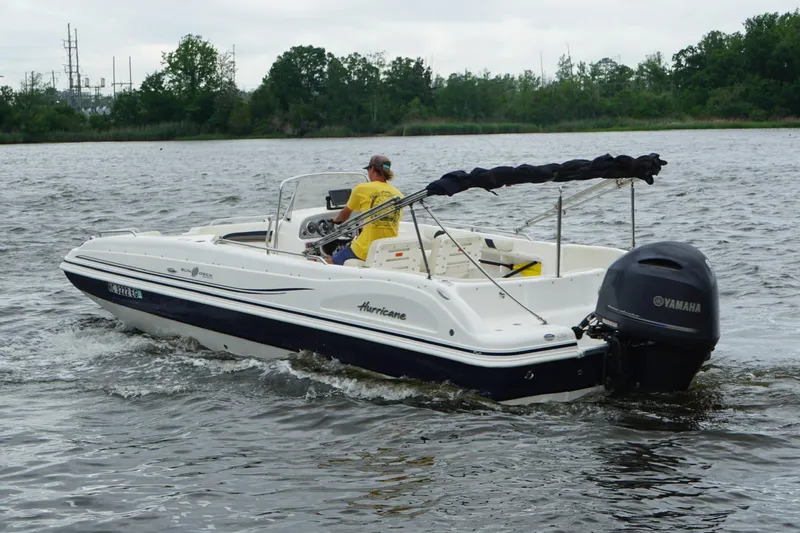 Slide: The Image of 2015 Hurricane SunDeck Sport 231 OB boat cruising on a lake with Yamaha outboard motor. - 15