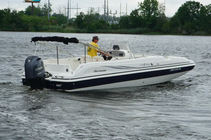 Slide: The Image of 2015 Hurricane SunDeck Sport 231 OB boat cruising on a calm lake. - 16